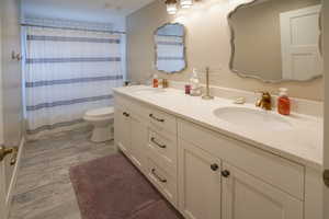 Full bath with double vanity and toilet