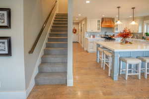 Stairs featuring wood finished floors and recessed lighting