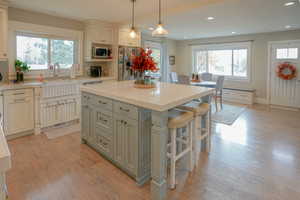 Kitchen with a center island, hanging light fixtures, light wood finished floors, recessed lighting, and stainless steel appliances