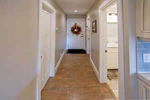 Hall with dark wood-style flooring and baseboards