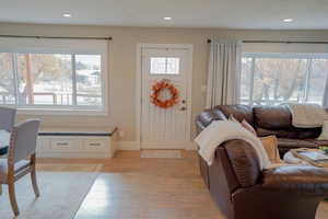 Foyer entrance with light wood-style flooring and recessed lighting