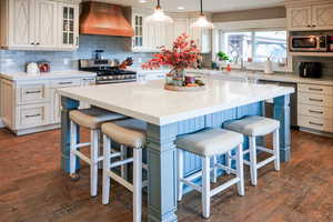 Kitchen featuring backsplash, a kitchen island, blue cabinets, light stone counters, and recessed lighting