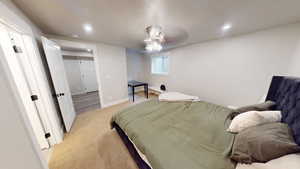 Bedroom featuring a textured ceiling, light colored carpet, a ceiling fan, and recessed lighting