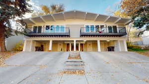 View of front of property with a carport, driveway, and a balcony