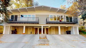 View of front facade featuring a carport, a balcony, and driveway