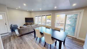 Dining room featuring recessed lighting, a textured ceiling, wood finished floors, and lofted ceiling