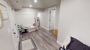 Playroom with light wood-style floors, recessed lighting, a textured ceiling, and washer / dryer