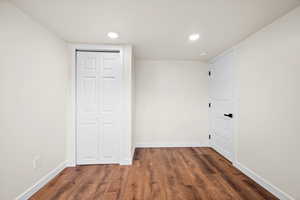 Empty room featuring dark wood-style flooring and recessed lighting