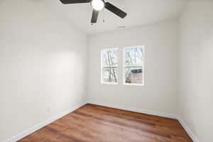 Empty room featuring dark wood-style flooring and ceiling fan