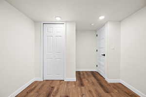 Corridor with a textured ceiling and dark wood-type flooring