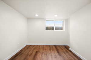 Unfurnished room featuring dark wood-style flooring and recessed lighting