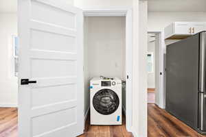 Laundry area with washer / dryer and dark wood-type flooring