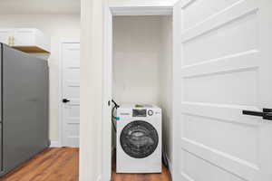 Washroom with washer / dryer and wood finished floors