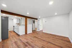 Kitchen featuring stainless steel appliances, recessed lighting, white cabinetry, light wood-type flooring, and a textured ceiling