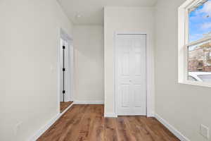Unfurnished bedroom featuring dark wood-style flooring and a closet