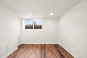 Spare room with wood finished floors and a textured ceiling