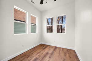 Spare room with wood finished floors and ceiling fan