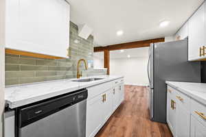 Kitchen with stainless steel appliances, light stone counters, dark wood finished floors, backsplash, and recessed lighting