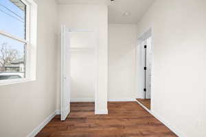 Unfurnished bedroom featuring dark wood-style floors and a closet