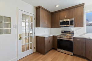 Kitchen featuring appliances with stainless steel finishes, light wood finished floors and modern cabinets