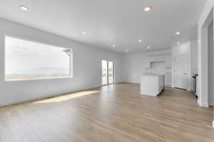 Unfurnished living room with recessed lighting, light wood finished floors, and a textured ceiling