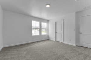 Unfurnished bedroom with light carpet and a textured ceiling