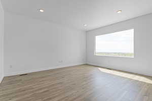 Unfurnished room featuring light wood finished floors, recessed lighting, and a textured ceiling