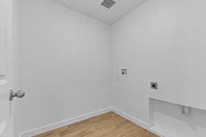 Laundry room featuring light wood-style flooring, electric dryer hookup, and hookup for a washing machine
