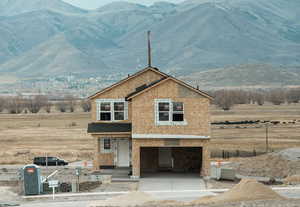 View of front of home with a porch, a mountain view, concrete driveway, and an attached garage