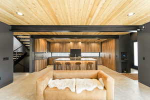 Kitchen with modern cabinets, recessed lighting, brown cabinets, a breakfast bar, and a center island with sink