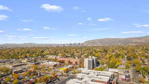 View of urban area featuring a mountain backdrop and a tree filled landscape