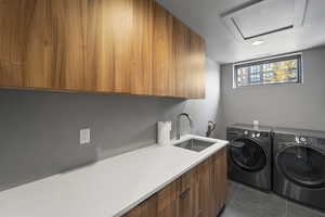 Washroom with washing machine and clothes dryer, cabinet space, and dark tile patterned flooring