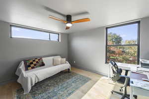 Office area with light wood finished floors and a ceiling fan