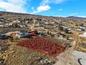 Aerial perspective of suburban area with property parcel outlined and mountains