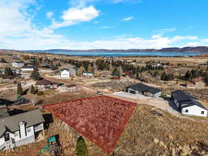Aerial view of property and surrounding area featuring property parcel outlined and a water and mountain view
