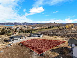 Aerial view of property and surrounding area with property parcel outlined and a water and mountain view