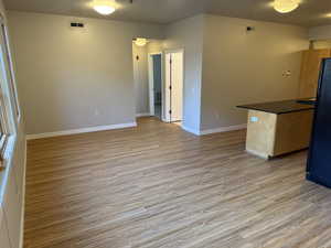 Kitchen featuring light wood-style floors, freestanding refrigerator, and open floor plan