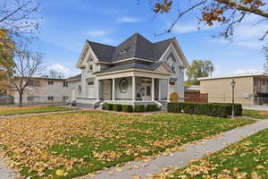 View of front of home with a porch and a shingled roof