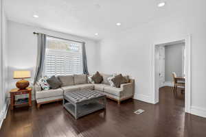 Living room with recessed lighting, dark wood-style floors, and a textured ceiling