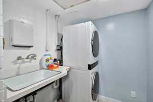 Washroom featuring stacked washer and clothes dryer