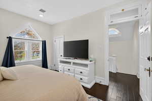 Bedroom featuring dark wood-style flooring and baseboards