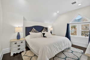 Bedroom with dark wood-style flooring, lofted ceiling, and recessed lighting
