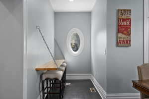 Office space with baseboards and dark wood-style flooring