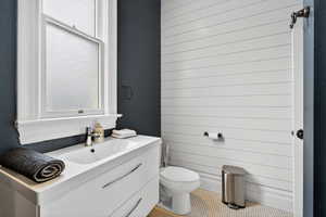 Half bathroom with vanity and tile patterned flooring