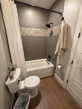 Full bathroom with light wood-style floors and shower / tub combo