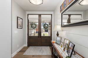 Entryway with wood finished floors and french doors.