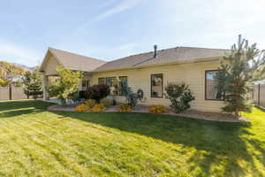 Rear view of property featuring a shingled roof and a patio area.