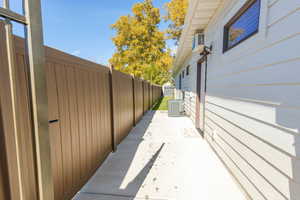 View of side of home featuring a patio area and a cooling unit.