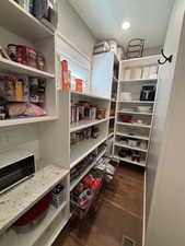 View of pantry with pull out shelving and high ceilings.