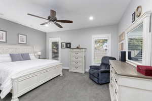 Bedroom featuring light colored carpet, a ceiling fan, and recessed lighting.